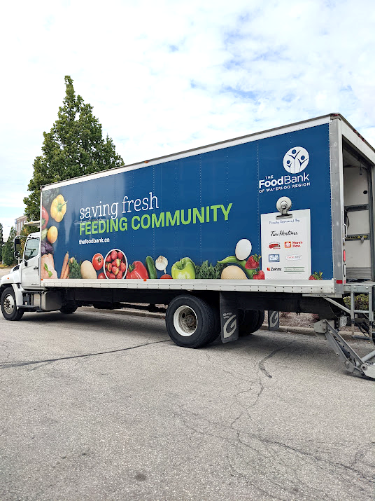 Large blue truck with the text 'Serving fresh. Feeding Community"